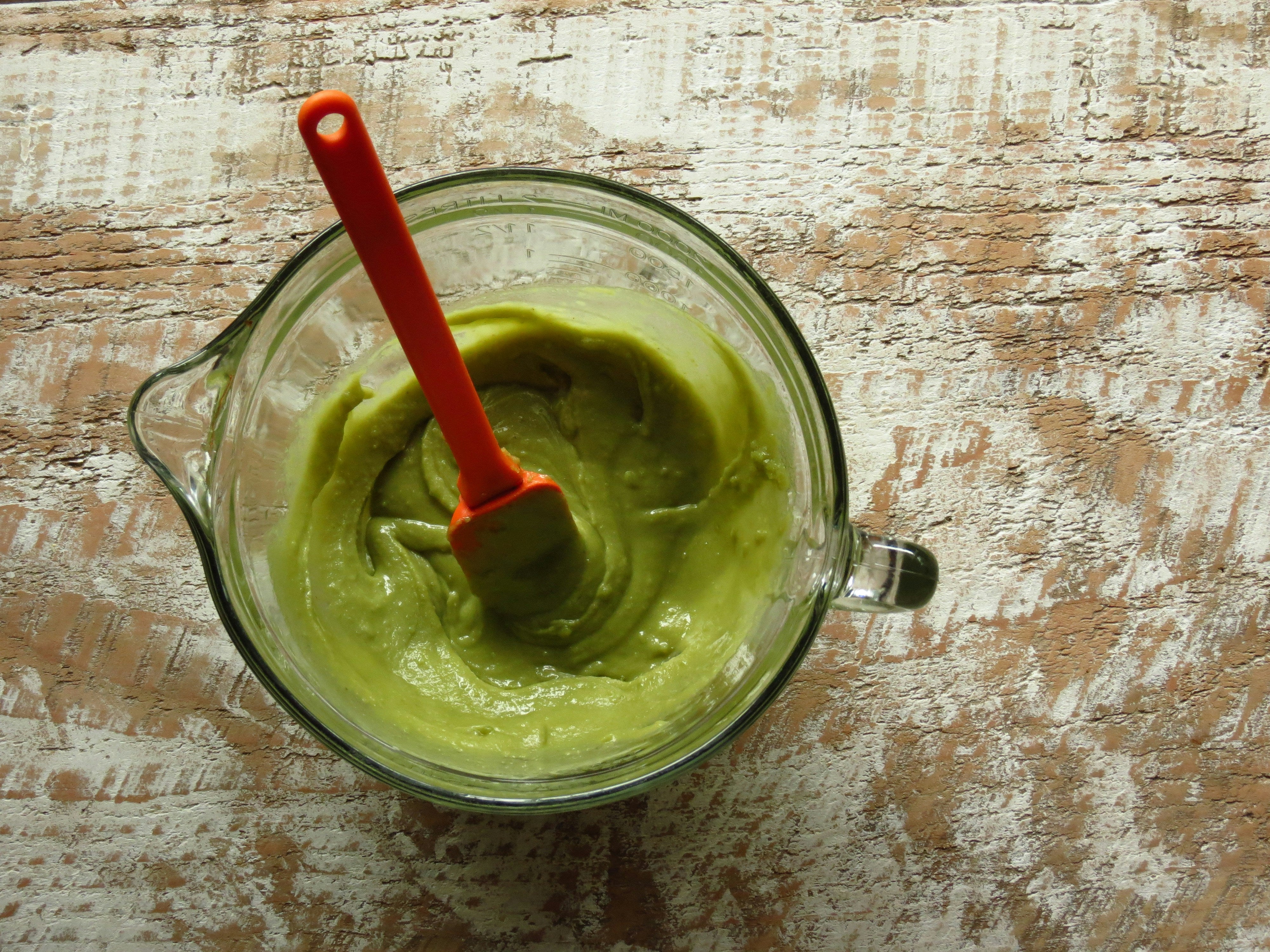 Cannabis infused butter in a glass measuring cup with spatula