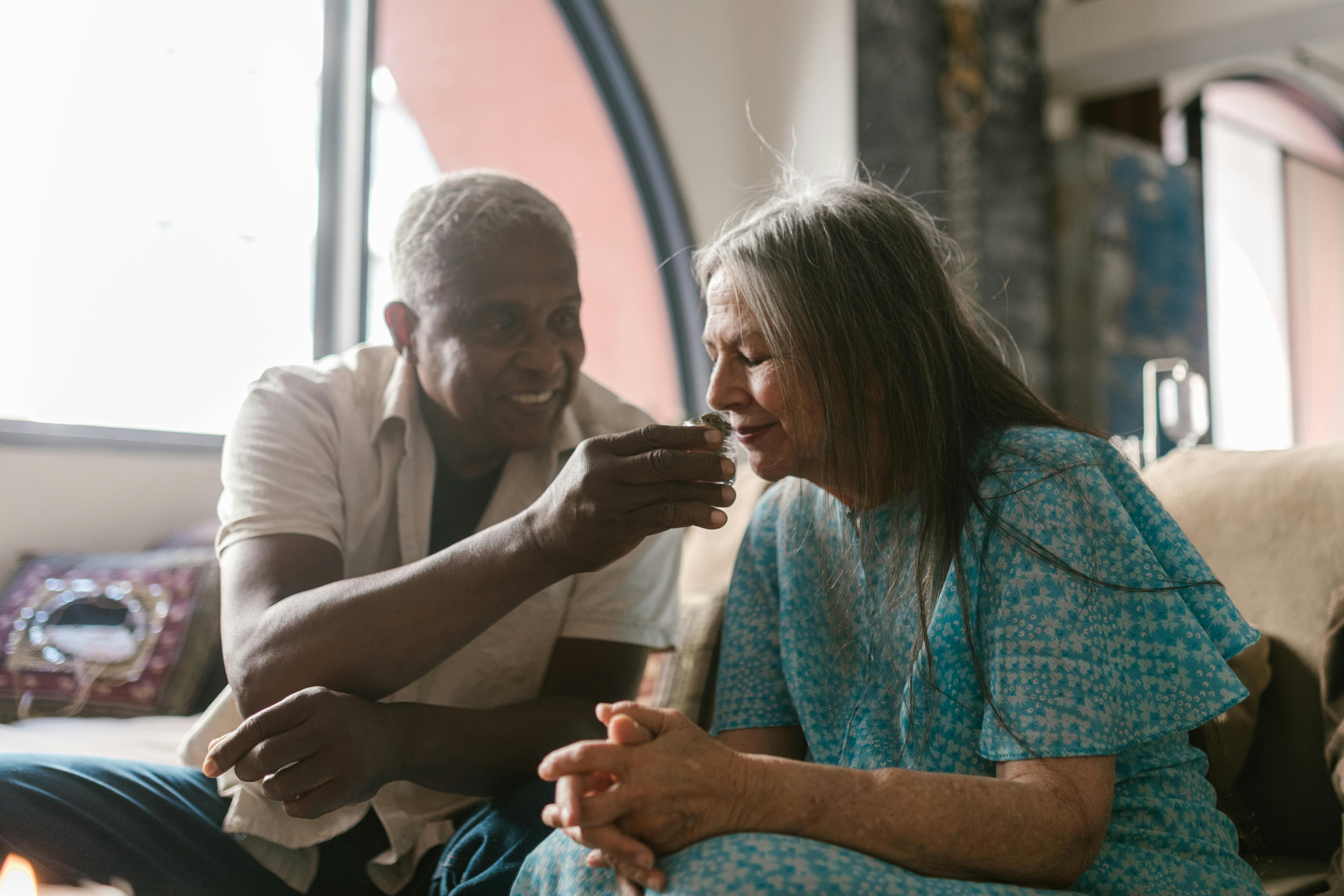 Man holding cannabis bud under a woman's nose